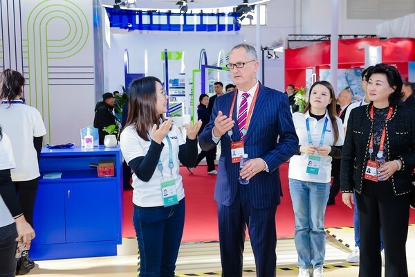 Visa公司亚太区董事长柯如龙（中）出席了首届中国国际供应链促进博会并参观展台