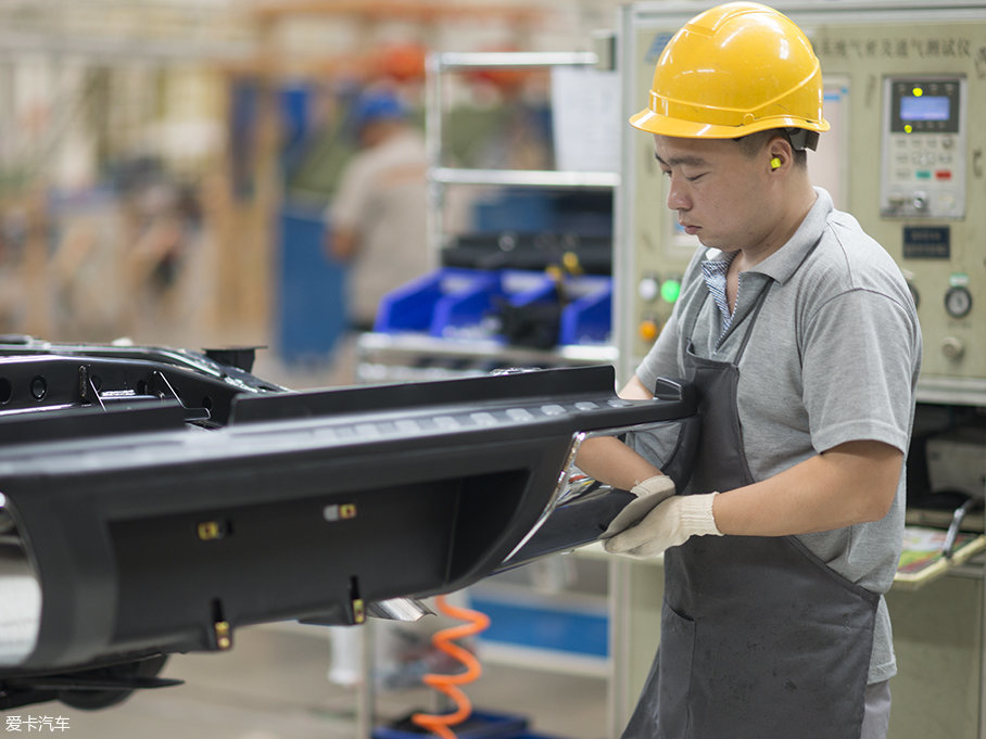 在非承载式车身底盘分装线上,工人正在安装纳瓦拉的后保险杠.